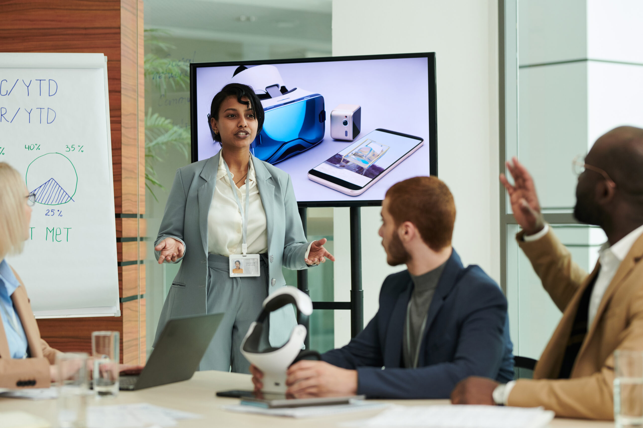 Confident coach or speaker making presentation of vr headset on interactive board in front of audience during seminar or training